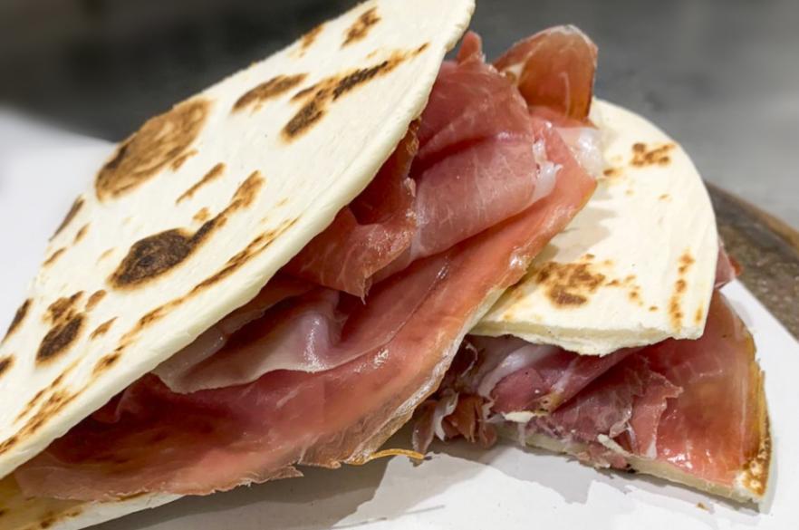 Piadina con prosciutto crudo, tipica specialità italiana, dal gusto ricco e saporito.